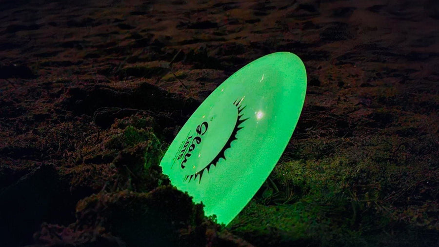 Charged glow disc golf disc on the course after dark